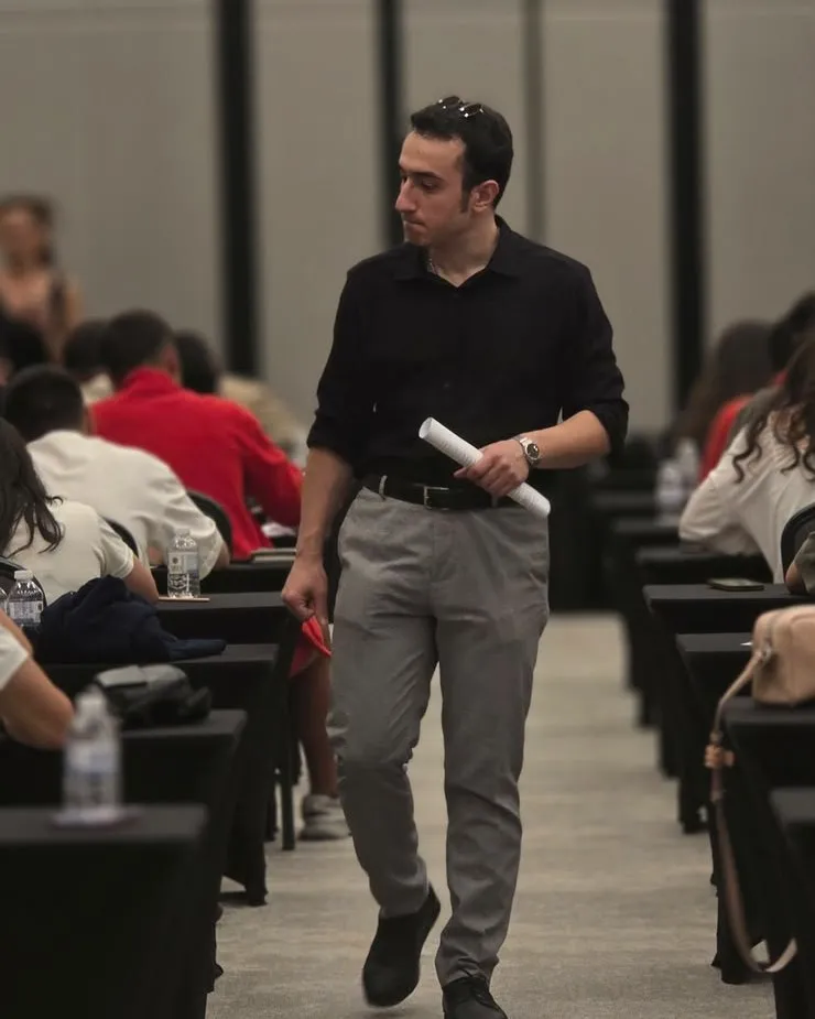 Sınav sırasında sıralar arasında ilerleyen Niz Eğitim görevlisi